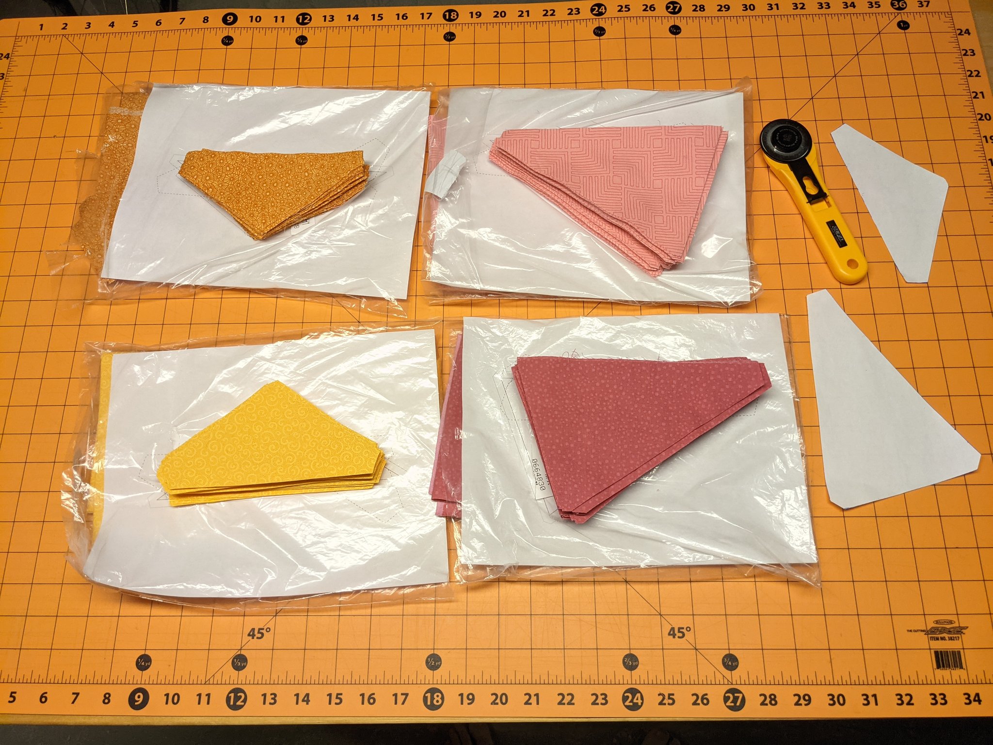 Cut-out half-tiles in orange, yellow, light pink, and dark pink